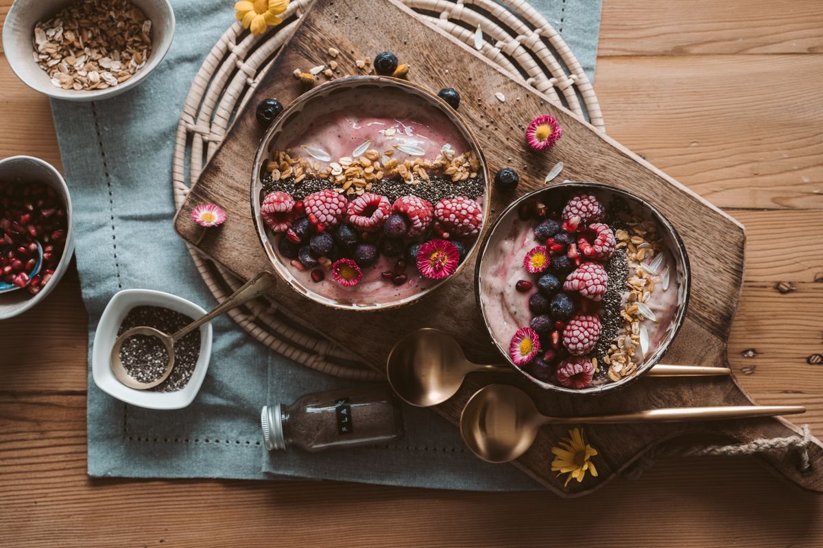Two smoothie bowls with fresh berries and granola